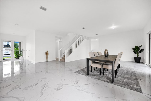 dining space with marble finish floor, visible vents, and stairway