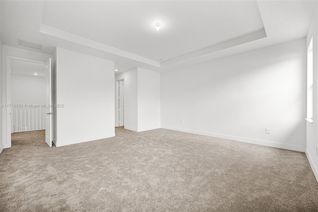unfurnished bedroom with a raised ceiling, baseboards, and carpet floors