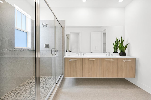 bathroom with recessed lighting, double vanity, a sink, and a stall shower