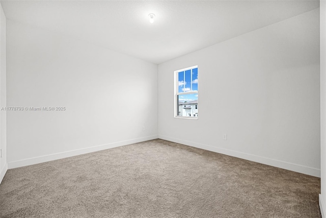 carpeted spare room with baseboards