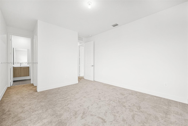 unfurnished bedroom with visible vents, baseboards, ensuite bathroom, and carpet