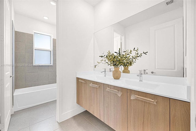 bathroom with visible vents, baseboards, a sink, double vanity, and tile patterned floors