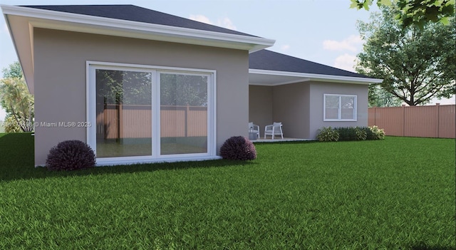 509 Glendale Ave, La Belle, FL 33935 - back of property featuring roof with shingles, stucco siding, fence, and a lawn