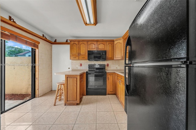 15026 SW 96th Ter, Miami, FL 33196 - kitchen with a kitchen breakfast bar, tasteful backsplash, black appliances, light tile patterned flooring, and light countertops