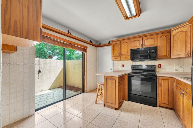 15026 SW 96th Ter, Miami, FL 33196 - kitchen featuring a breakfast bar, brown cabinets, light countertops, and black appliances