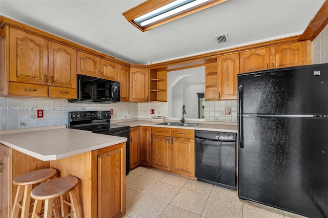 15026 SW 96th Ter, Miami, FL 33196 - kitchen featuring brown cabinetry, visible vents, a sink, and black appliances