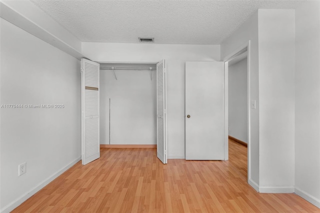 15026 SW 96th Ter, Miami, FL 33196 - unfurnished bedroom featuring a textured ceiling, a closet, light wood finished floors, and visible vents