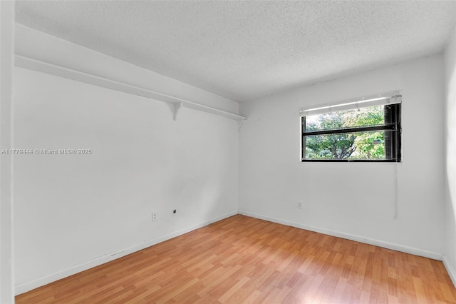 15026 SW 96th Ter, Miami, FL 33196 - unfurnished room with light wood-style flooring, a textured ceiling, and baseboards