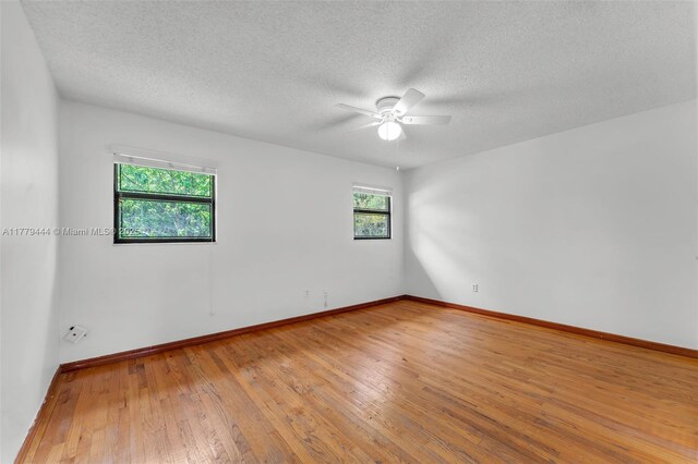 15026 SW 96th Ter, Miami, FL 33196 - spare room featuring wood-type flooring, a ceiling fan, and baseboards