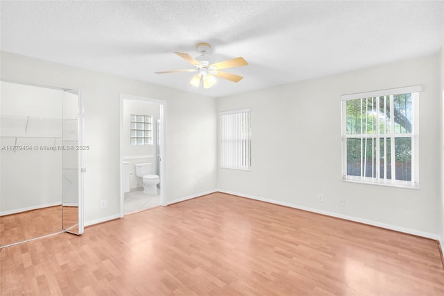 1617 Zenith Way, Weston, FL 33327 - unfurnished bedroom featuring light wood-style flooring, a closet, a spacious closet, baseboards, and ensuite bathroom
