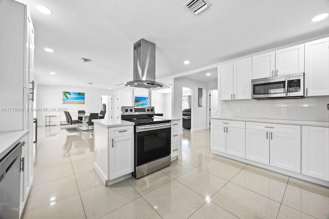 820 W Chaminade Dr, Hollywood, FL 33021 - kitchen featuring visible vents, light countertops, appliances with stainless steel finishes, island exhaust hood, and backsplash