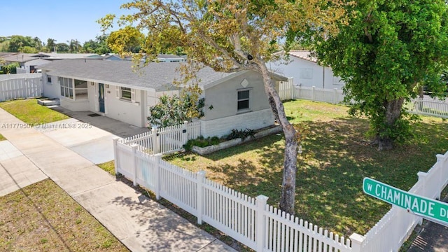 820 W Chaminade Dr, Hollywood, FL 33021 - view of front of house featuring a front yard, roof with shingles, a fenced backyard, and stucco siding