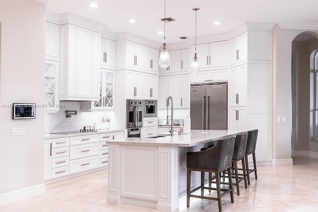 5025 Regency Isles Way, Cooper City, FL 33330 - kitchen with white cabinets, stainless steel appliances, a sink, arched walkways, and baseboards