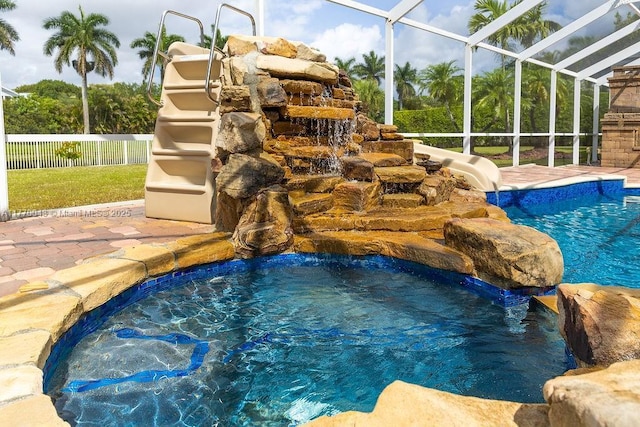 5025 Regency Isles Way, Cooper City, FL 33330 - view of pool with a fenced in pool, a water slide, fence, glass enclosure, and a hot tub