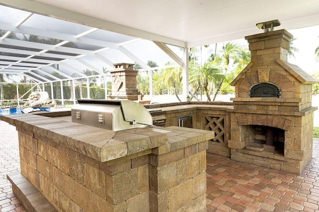 5025 Regency Isles Way, Cooper City, FL 33330 - view of patio with a grill, an outdoor stone fireplace, glass enclosure, and area for grilling