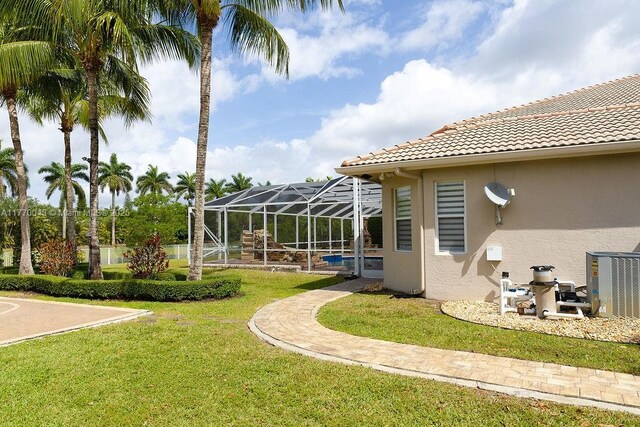 5025 Regency Isles Way, Cooper City, FL 33330 - view of yard with central AC unit, an outdoor pool, and glass enclosure