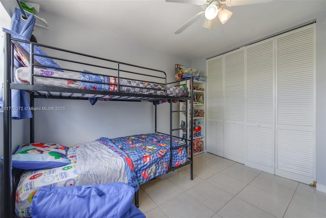 bedroom with a ceiling fan, tile patterned floors, and a closet