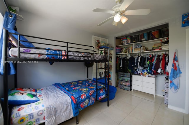 bedroom with a ceiling fan, tile patterned flooring, and a closet