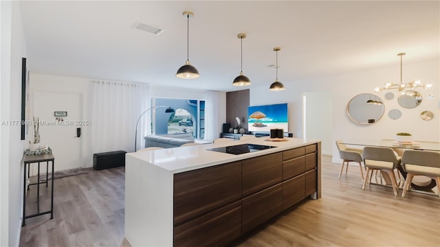 10300 NW 80th Ct, Tamarac, FL 33321 - kitchen with modern cabinets, light wood-type flooring, light countertops, a chandelier, and pendant lighting