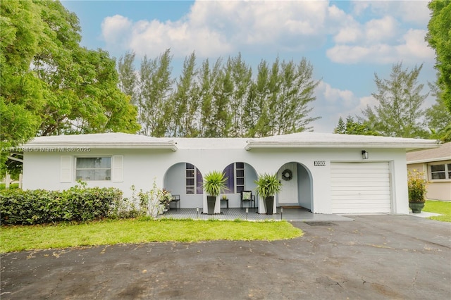 10300 NW 80th Ct, Tamarac, FL 33321 - view of front of home featuring a garage, driveway, a porch, and stucco siding