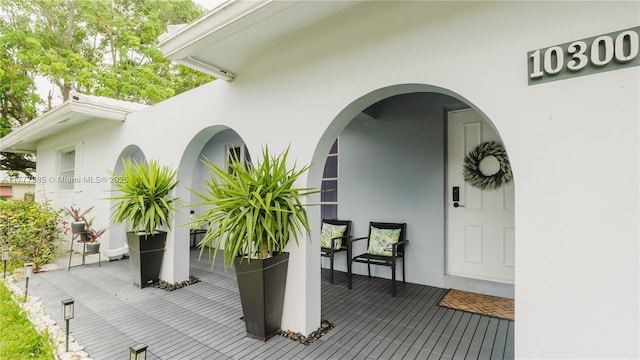 10300 NW 80th Ct, Tamarac, FL 33321 - view of exterior entry featuring stucco siding and a wooden deck