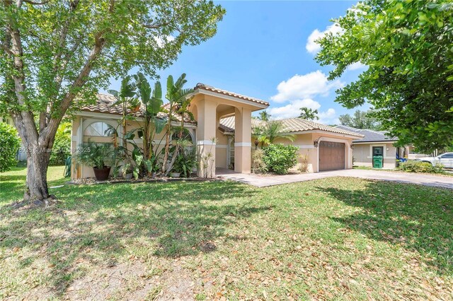 4622 NW 100th Ter, Coral Springs, FL 33076 - mediterranean / spanish-style home featuring concrete driveway, an attached garage, a front lawn, stucco siding, and a tile roof