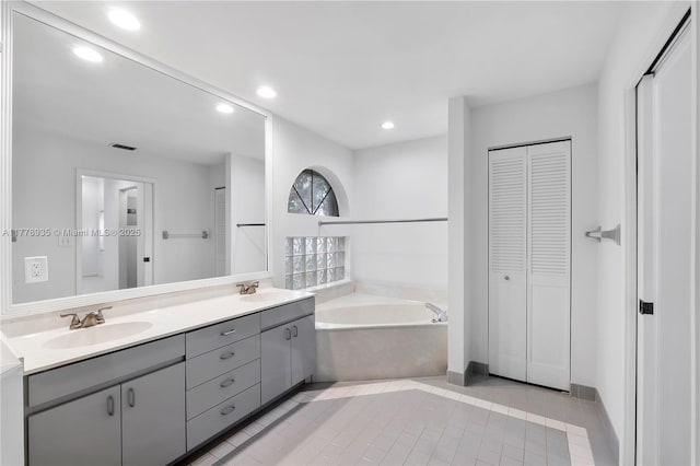 4622 NW 100th Ter, Coral Springs, FL 33076 - bathroom with a closet, double vanity, a bath, recessed lighting, and tile patterned flooring