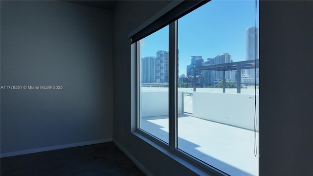 10 SW S River Dr Unit 610, Miami, FL 33130 - spare room featuring a view of skyline, baseboards, and carpet