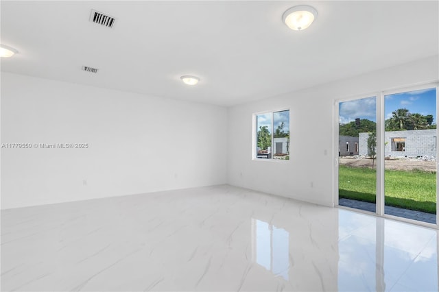 spare room with marble finish floor and visible vents