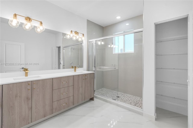 full bath featuring a sink, a shower stall, marble finish floor, and double vanity