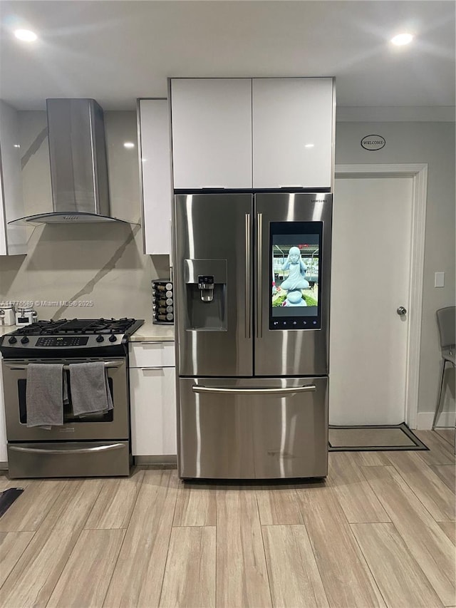 428 N Crescent Dr, Hollywood, FL 33021 - kitchen featuring stainless steel appliances, wall chimney range hood, white cabinetry, and light wood finished floors