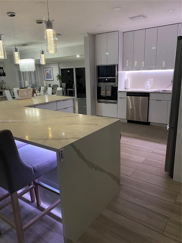 428 N Crescent Dr, Hollywood, FL 33021 - kitchen featuring stainless steel appliances, wood finished floors, and white cabinetry