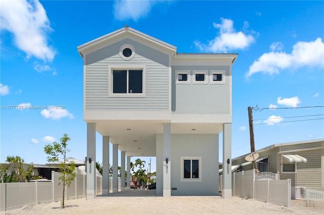 view of front facade featuring fence and a carport