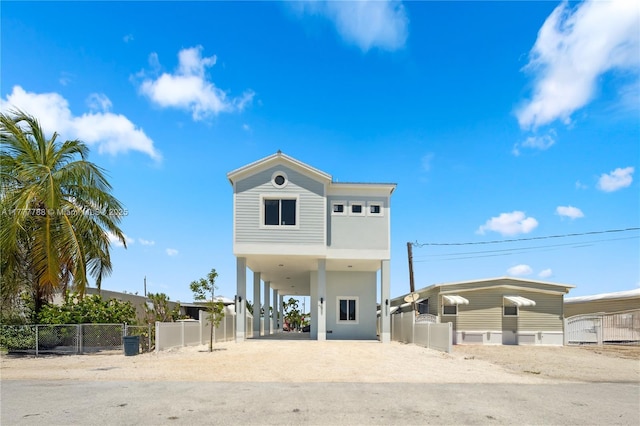 view of front of property with a carport, driveway, and fence