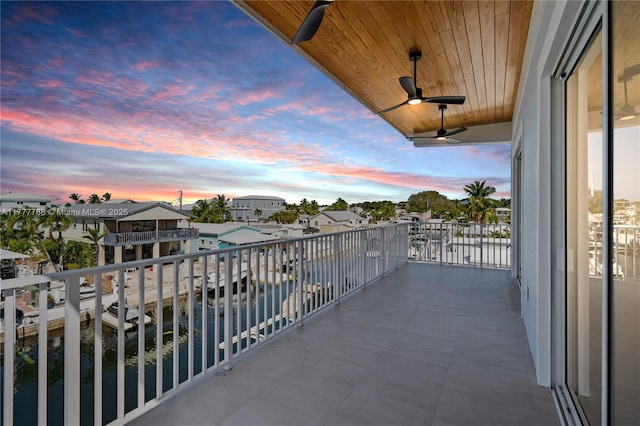balcony at dusk featuring ceiling fan