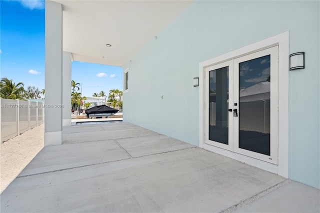 view of patio / terrace featuring fence and french doors