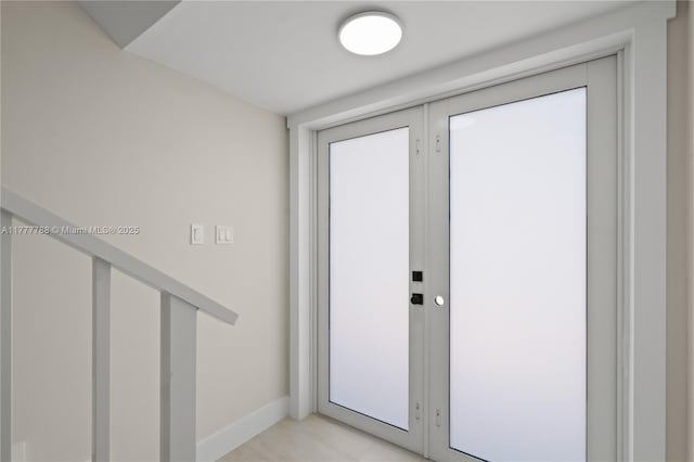 doorway with baseboards and french doors