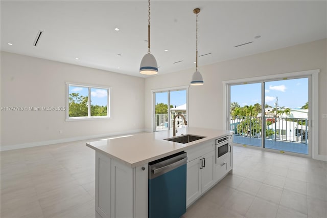 kitchen featuring a wealth of natural light, dishwashing machine, a sink, and open floor plan