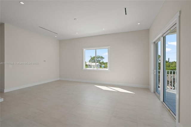 empty room featuring baseboards, recessed lighting, and a healthy amount of sunlight