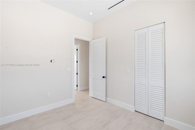 unfurnished bedroom featuring recessed lighting, baseboards, and a closet