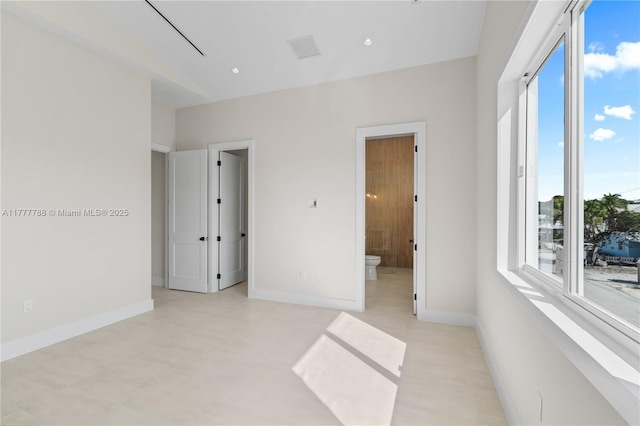 unfurnished bedroom with ensuite bath, visible vents, baseboards, and multiple windows