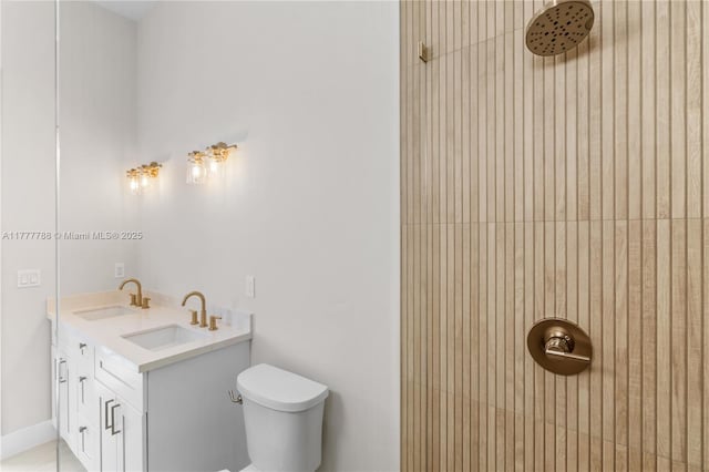 full bath featuring toilet, a sink, double vanity, and tiled shower