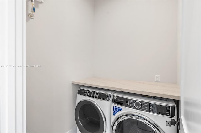 clothes washing area with washing machine and dryer and laundry area