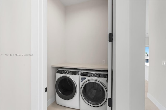 clothes washing area featuring separate washer and dryer, baseboards, laundry area, and light tile patterned floors