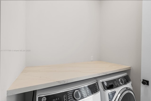 clothes washing area with washing machine and clothes dryer and laundry area
