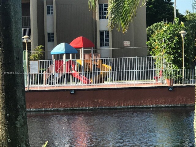 5112 NW 79th Ave Unit 201, Doral, FL 33166 - exterior space featuring a water view, fence, and playground community