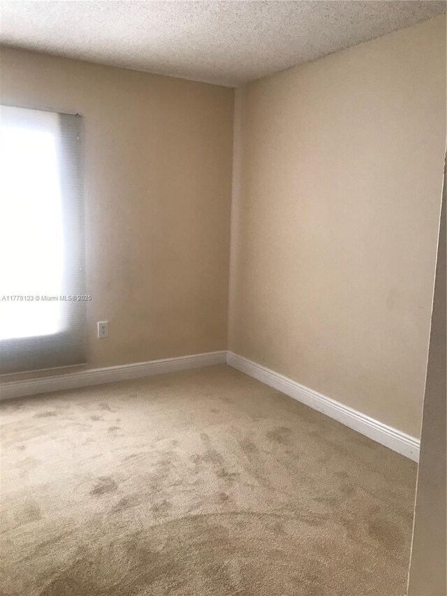 5112 NW 79th Ave Unit 201, Doral, FL 33166 - unfurnished room with a textured ceiling, light colored carpet, and baseboards