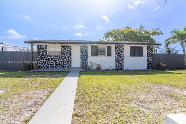 view of front facade featuring stucco siding, fence, and a front lawn