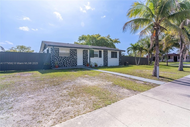 view of front of property featuring fence and a front lawn