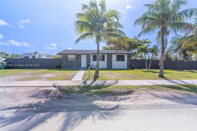 view of front of home with a front yard and fence